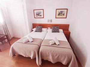 1 dormitorio con 1 cama grande y 2 almohadas en Apartaments Mare Nostrum, en Sitges