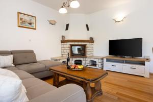 a living room with a couch and a fireplace at Villa Eirene in Drivenik