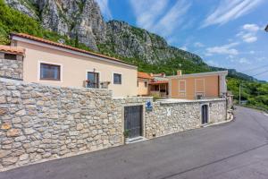 a house with a stone wall and a mountain at Villa Banely in Grižane