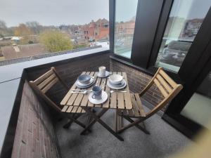 una mesa y sillas en un balcón con vistas en Gezellig appartement in Brugge, nabij Damme. en Brujas
