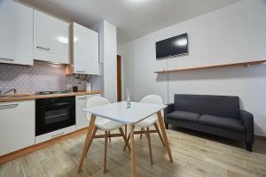 een keuken met een tafel en stoelen en een bank bij Flat Number 8 in Milaan
