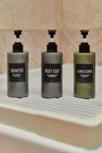 three bottles of soap sitting on top of a sink at Flat Number 8 in Milan
