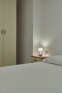 a bedroom with a bed and a table with a lamp at Flat Number 8 in Milan