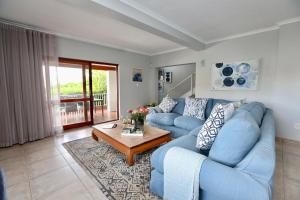a living room with a blue couch and a coffee table at Above & Beyond Houtbay in Hout Bay