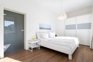シャルボイツにあるFerienwohnung Capolinoの白いベッドルーム(大型ベッド1台、窓付)
