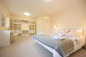 a bedroom with a large bed and a kitchen at Summerfold in Warkworth