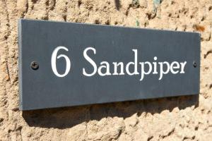 a sign on the side of a building at Sandpiper Alnmouth in Alnmouth