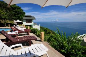 a patio with tables and chairs and the ocean at Phangan Utopia Resort in Mae Haad