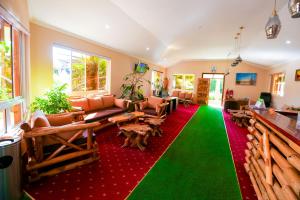 een woonkamer met een rood en groen tapijt bij Aberdare Prestige & Royal Cottages in Nanyuki