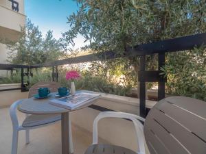a table and chairs on a balcony with a view of a tree at CASA AL MARE RESIDENCE in Bečići