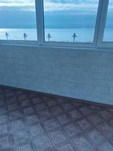 a room with a window looking out at the ocean at Victoria Hotel in Aktau