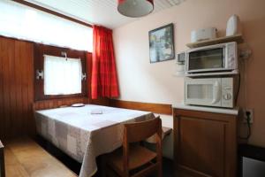 una pequeña cocina con mesa y microondas en Sapins A5 - Résidence Super Murat, en Murat-le-Quaire