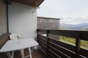 una mesa blanca y una silla en un balcón con vistas en Sapins A5 - Résidence Super Murat, en Murat-le-Quaire