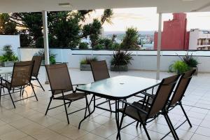 a table and chairs sitting on a patio at VOW Departamento CÉNTRICO CON COCHERA in Villa Carlos Paz