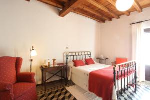 a bedroom with a bed and a chair at Posada de Amonaria in Malpartida de Plasencia