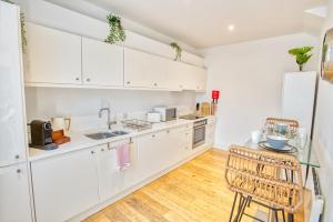 a kitchen with white cabinets and a table and chairs at Centrally Located Apartment - Pass the Keys in Lincoln