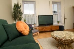 a living room with a green couch and a television at Centrally Located Apartment - Pass the Keys in Lincoln +30 photos