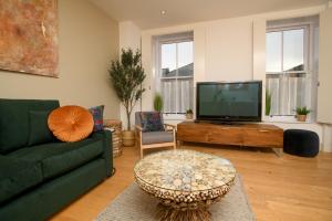 a living room with a green couch and a tv at Pass the Keys Centrally Located Apartment in Lincoln