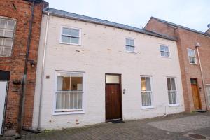 an old white brick building with a brown door at Pass the Keys Centrally Located Apartment in Lincoln
