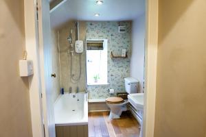 a bathroom with a shower and a toilet and a sink at Laverstock Cottage in Bridport