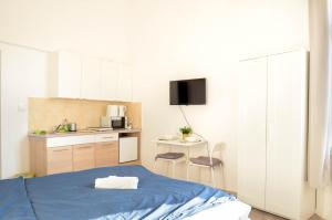 um quarto com uma cama azul e uma cozinha em Papnövelde Royal Inn @Inner City em Budapeste