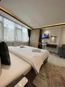 una camera con un grande letto e una televisione di Blue Mansion Hotel & Flats a Istanbul