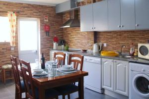 a kitchen with a table with chairs and a sink at Casa Andreia, close to everything in Lagos