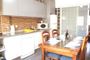 a kitchen with a table with chairs and a microwave at Casa Andreia, close to everything in Lagos