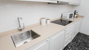 a kitchen counter with a sink and a microwave at Casa Soure Suites and Apartments in Évora
