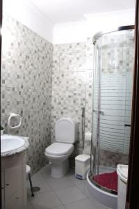 a bathroom with a toilet and a glass shower at Casa Andreia, close to everything in Lagos +11 photos
