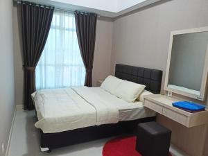 Un pat sau paturi într-o cameră la Apartemen Borneo Bay City Balikpapan