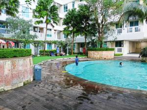 two children playing in the swimming pool at a resort at Apartemen Borneo Bay City Balikpapan in Klandasan Kecil