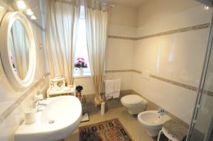 Un baño con lavabo, inodoro y ventana. en Delizioso appartamento, en Feltre 11 fotos más