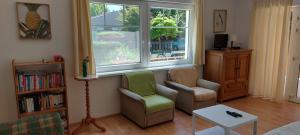 a living room with two chairs and a window at Schieszl Apartments Zamárdi 4 in Zamárdi