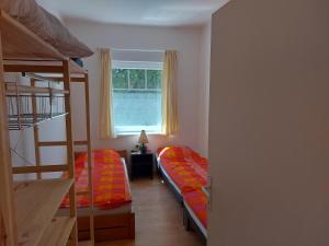 Cette chambre comprend 2 lits superposés et une fenêtre. dans l'établissement Schieszl Apartments Zamárdi 4, à Zamárdi