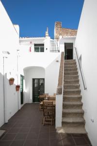 a staircase leading up to a white house with a table at Casa Soure Suites and Apartments in Évora