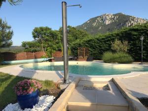 a swimming pool with a mountain in the background at Le Jardin des Gorges in Belvianes-et-Cavirac