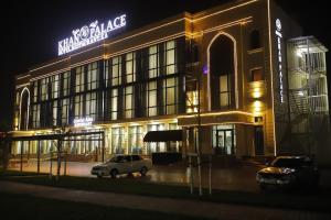 a building with a car parked in front of it at night at Khan Palace in Türkistan