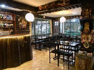ナガルコットにあるHotel New Dragonの部屋にテーブルと椅子があるレストラン