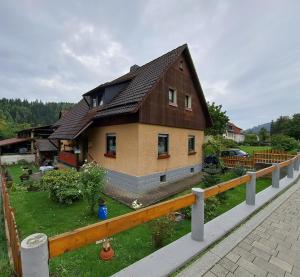 un modelo de casa con una valla en Ferienwohnung Sonja mit Garten und Freisitz, en Steinwiesen