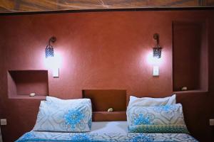 Munga Eco-Lodge في ليفينغستون: غرفة نوم بسريرين واضاءتين على الحائط