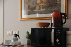 Un microondas sobre una encimera con una cafetera encima. en Delizioso appartamento, en Feltre