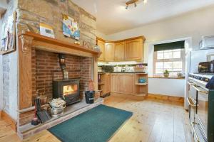 a living room with a brick fireplace in a kitchen at Turnstone Cottage in Bamburgh