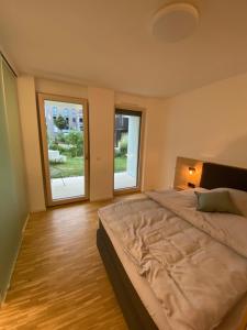a bedroom with a large bed and two windows at Con4rent Business Hotel plus in Kirchheim unter Teck