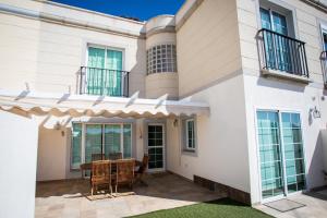 une maison avec un patio avec une table et des chaises dans l'établissement Orquídea Holiday Modern House, à Mogán