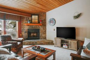 a living room with a tv and a fireplace at The Hip Rose in Big Sky