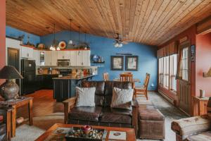 a living room with a leather couch and a kitchen at The Hip Rose in Big Sky