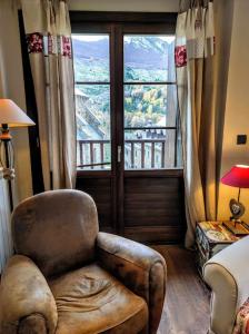 uma sala de estar com uma cadeira e uma grande janela em Casa Churdo II - tucasaenlospirineos em Lanuza