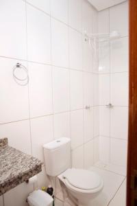 a white bathroom with a toilet and a shower at 102-FLAT-Espaço, conforto. É disso que você precisa! in Anápolis