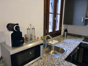 um balcão de cozinha com um lavatório e um micro-ondas em Casa Churdo II - tucasaenlospirineos em Lanuza